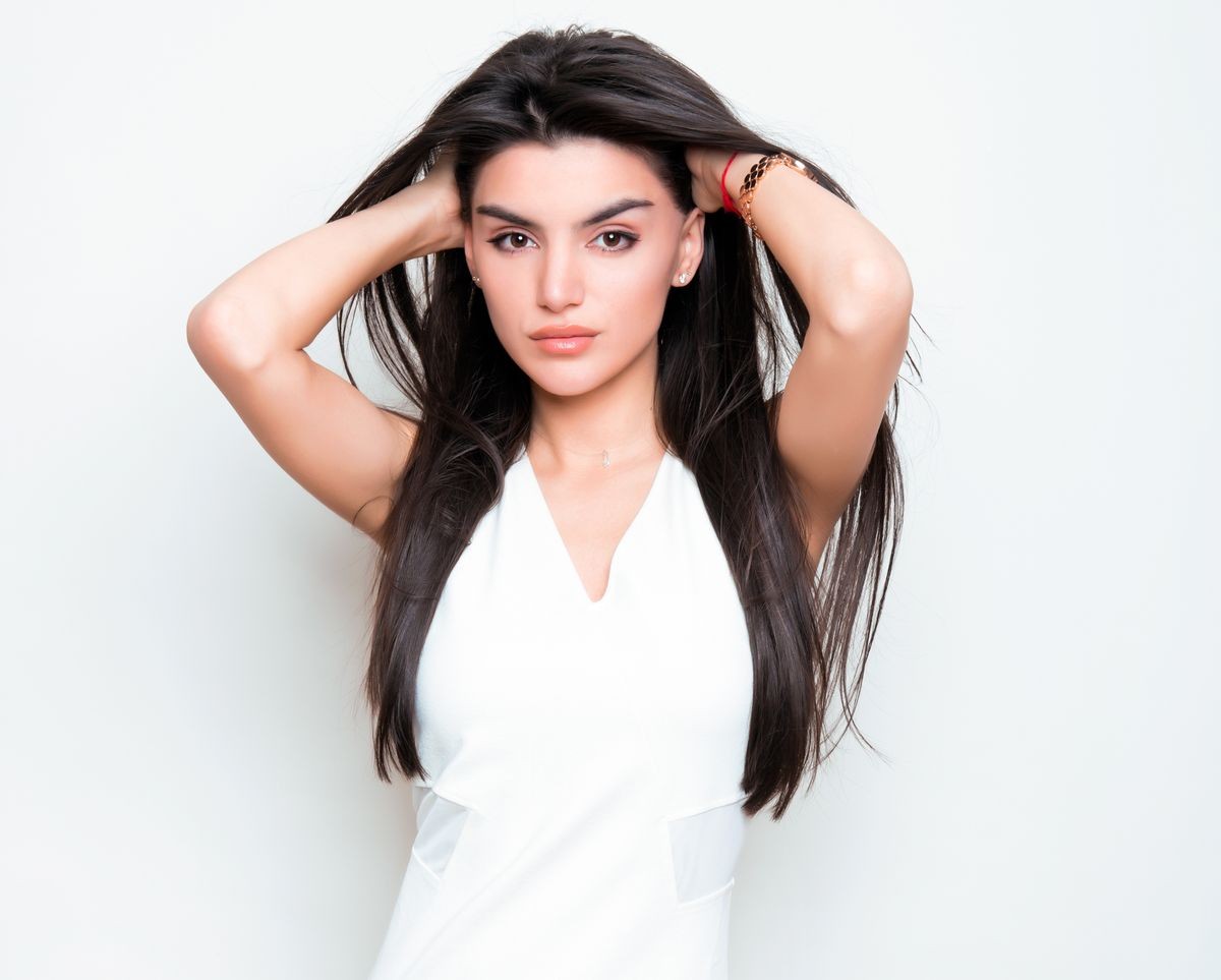 beautiful young woman with long black hair wearing white dress